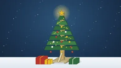Sapin de Noël en bois de palette décoré d'une guirlande et de boules, étoile dorée, paquets au pied, sous la neige